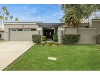 Charming single-story home featuring a well-manicured lawn and a two car garage at 8187 E Del Caverna Dr, Scottsdale, AZ 85258