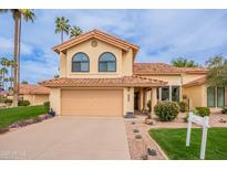 Charming two-story home featuring a well-manicured lawn, desert landscaping, and a two-car garage at 11731 N 91St Pl, Scottsdale, AZ 85260