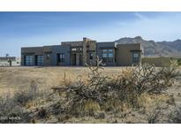 Modern desert home boasts a stone-accented facade with expansive windows and neutral color palette at 12801 E Mariposa Grande Dr, Scottsdale, AZ 85255