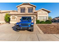Inviting two-story home showcasing desert landscaping, a two car garage, and a blue Jeep parked in the driveway at 1701 E Yukon Dr, Phoenix, AZ 85024