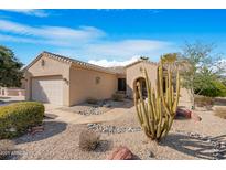 Charming single-story home with desert landscaping, including a saguaro cactus and rock accents at 18668 N Lariat Ct, Surprise, AZ 85387