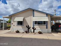 Charming manufactured home with desert landscaping, carport, and neutral color scheme under cloudy skies at 2460 E Main St # A2, Mesa, AZ 85213
