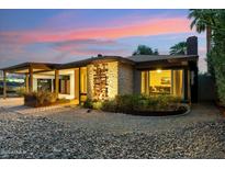 Charming home exterior featuring a stone facade, desert landscaping, and illuminated accents at 4130 N 4Th Ave, Phoenix, AZ 85013