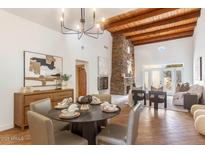 Open living room featuring a stone fireplace, wood ceiling, and round dining table at 6411 S River Dr # 32, Tempe, AZ 85283