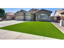 Single-Gathering home with a three-car garage, stone accents, desert landscaping and lush green turf at 854 S Del Rio Ct, Apache Junction, AZ 85120