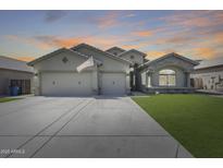 Charming single-story home featuring a three-car garage, stone accents and a well-manicured lawn at 854 S Del Rio Ct, Apache Junction, AZ 85120