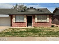 Charming single-story home features a brick facade, well-maintained lawn, and a cozy front entrance at 9638 W Cinnabar Ave # B, Peoria, AZ 85345