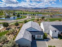 Stunning aerial view of a neighborhood featuring a golf course, water features, and mountain views at 11878 N Hershey St, Surprise, AZ 85388