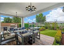 Relaxing outdoor patio featuring comfortable seating, an outdoor kitchen, and a landscaped yard at 11878 N Hershey St, Surprise, AZ 85388