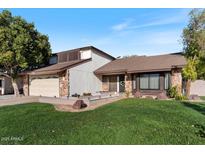 Charming two-story home showcasing a well-manicured lawn and attached two car garage in a suburban neighborhood at 12001 N 53Rd Ave, Glendale, AZ 85304