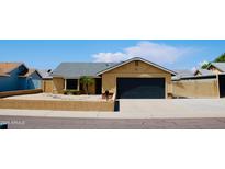 Charming single-story home featuring a two-car garage and low-maintenance desert landscaping at 16010 N 64Th Dr, Glendale, AZ 85306