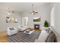 Bright living room featuring a fireplace, ceiling fan, vaulted ceilings, and contemporary decor at 16155 E Glenview Pl, Fountain Hills, AZ 85268