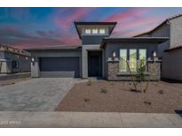 Charming single-Gathering home featuring modern architectural details, a two-car garage and desert landscaping at 21450 W Meadowbrook Ave, Buckeye, AZ 85396