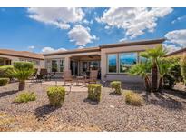 Landscaped backyard includes stone ground cover, lounge seating, and manicured shrubbery at 37036 N Stoneware Dr, Queen Creek, AZ 85140