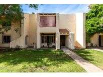 Charming townhome featuring a red and white striped awning and a well-manicured lawn at 5741 N 44Th Ln, Glendale, AZ 85301