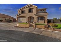 Inviting two-story home with landscaped front yard and charming architectural details and covered porch entrance at 7628 W Donald Dr, Peoria, AZ 85383