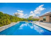 A stunning swimming pool and lounge area make this backyard perfect for relaxation and entertaining at 17936 E Colt Ct, Queen Creek, AZ 85142