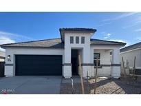 Contemporary home featuring a gray roof, neutral stucco, decorative stone accents, and a two-car garage at 25442 W Graham Trl, Buckeye, AZ 85326