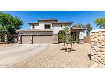 Stunning two-story home with a three-car garage and desert landscaping at 34990 N Spur Cir, San Tan Valley, AZ 85144