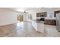 Open kitchen features tile flooring, an island, and stainless steel appliances at 11669 N 165Th Ave, Surprise, AZ 85388