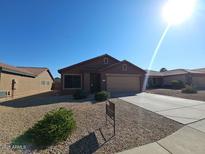 Inviting single-story home featuring a low-maintenance desert landscape and neutral color palette at 15581 W Caribbean Ln, Surprise, AZ 85379