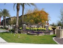 Exterior view of the Parkside Community with colorful landscaping, mature palm trees, and multi-story townhomes at 1920 E Bell Rd # 1073, Phoenix, AZ 85022