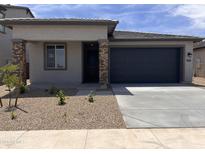 Charming single-story home featuring a two-car garage, desert landscaping, and a covered entryway at 23335 W Monona Ln, Surprise, AZ 85387