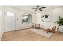 Bright living room featuring a ceiling fan, light hardwood floors, and a window with natural light at 252 S Cholla St, Gilbert, AZ 85233