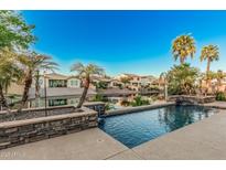 Relaxing pool with waterfall feature and lush landscaping overlooking the serene lake at 612 E Riviera Dr, Chandler, AZ 85249