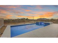 Beautiful private pool with a serene waterfall feature and mountain views at 14782 W Belmont Dr, Casa Grande, AZ 85194