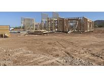 A home in the early stages of construction showcases its sturdy wood frame and promising design under a bright blue sky at 1920 E Creek Canyon Rd, Phoenix, AZ 85086
