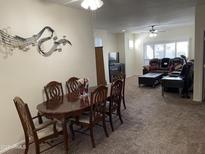 Spacious living and dining room with carpet, ceiling fan, and large windows at 7401 W Arrowhead Clubhouse W Dr # 1015, Glendale, AZ 85308