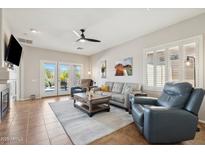 Bright living room featuring tile floors, ceiling fan, neutral paint, and access to the backyard at 10134 E Meandering Trail Ln, Gold Canyon, AZ 85118
