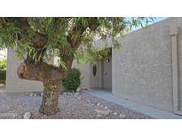 Inviting home exterior features a desert landscaped yard and a light-colored stucco facade, with a mature tree at the front at 16616 E Palisades Blvd # 109, Fountain Hills, AZ 85268