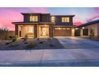 Charming two-story home featuring a well-manicured front yard and an attached two-car garage at 19443 W Valle Vista Way, Litchfield Park, AZ 85340