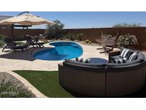 Inviting backyard pool and patio, perfect for relaxing and entertaining with stylish outdoor furniture and desert landscaping at 26904 W Kerry Ln, Buckeye, AZ 85396