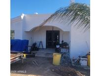 Inviting front entrance with an arched porch, stucco walls and double doors needs some TLC at 317 W Frontier St, Apache Junction, AZ 85120