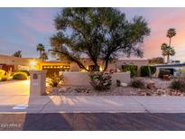 Charming single-story home with desert landscaping, mature trees, and a well-maintained stucco facade at sunset at 3258 E Vogel Ave, Phoenix, AZ 85028