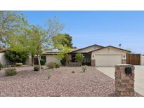 Charming single-story home with desert landscaping, stone accents, and a two-car garage under a clear blue sky at 12809 N 50Th St, Scottsdale, AZ 85254