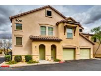 A two-story townhome with a private garage and light yellow stucco exterior and a red tile roof at 14575 W Mountain View Blvd # 925, Surprise, AZ 85374