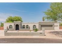 Charming single-story home with stucco facade, arched windows, desert landscaping, and a two-car garage at 15602 N 56Th Pl, Scottsdale, AZ 85254