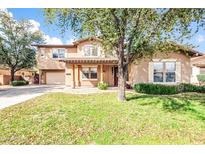 Charming two-story home featuring a covered porch and well-maintained lawn at 18544 E Caledonia Dr, Queen Creek, AZ 85142