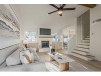 Bright living room with a fireplace, neutral tones, and staircase access at 18624 N 4Th Ave, Phoenix, AZ 85027