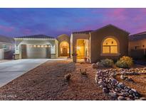 Charming home exterior boasts desert landscaping, covered porch, and attached two-car garage with decorative windows at 19675 E Oriole Way, Queen Creek, AZ 85142