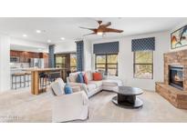 Inviting living room featuring a cozy fireplace, modern furnishings, and an open layout with abundant natural light at 21320 N 56Th St # 2005, Phoenix, AZ 85054