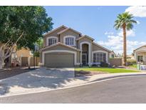 Charming two-story home with a well-manicured lawn, a palm tree, and a driveway at 2640 S Terripin Cir, Mesa, AZ 85209