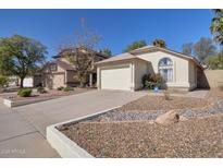 Charming single-story home featuring a two-car garage, arched window, and low-maintenance desert landscaping at 3036 E Bluefield Ave, Phoenix, AZ 85032