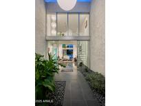 Inviting entrance showcasing a modern design with glass walls, a spiral staircase, and lush greenery at 4670 N 40Th St, Phoenix, AZ 85018