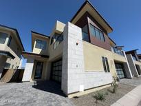 Modern two-story home featuring a stucco and stone exterior with glass garage doors under a clear blue sky at 1 Easy St # 3, Carefree, AZ 85377