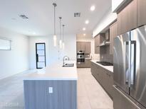 Modern kitchen features stainless steel appliances, gray cabinets, a gas cooktop, and a large quartz countertop island at 1 Easy St # 6, Carefree, AZ 85377